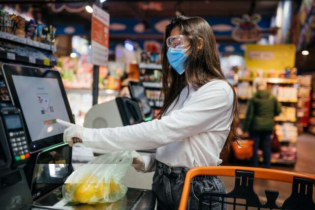 Girl with mask use PoS in supermarket