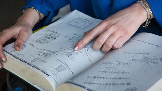 Instruction couple of hands on a book with technical drawings